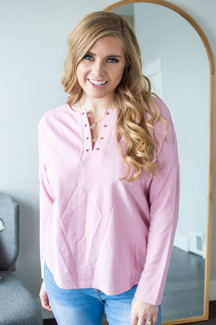 Model wearing pink long sleeve shirt.