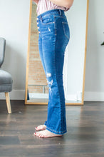 Load image into Gallery viewer, Side view of model wearing flare jeans.

